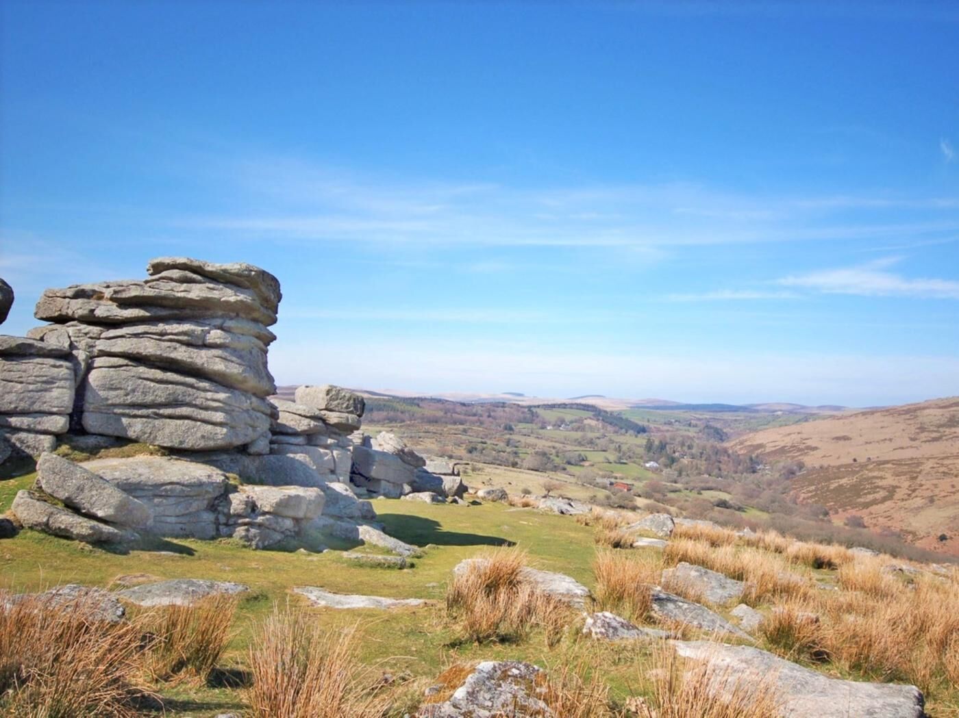 A landscape with a stack of large rocks and a valley in the distance.