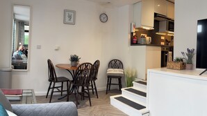 A modern apartment with a dining area, kitchen, and living room.