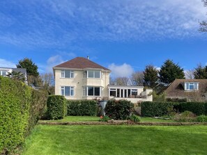 Ein zweistöckiges Haus mit Garten vor der Fassade.