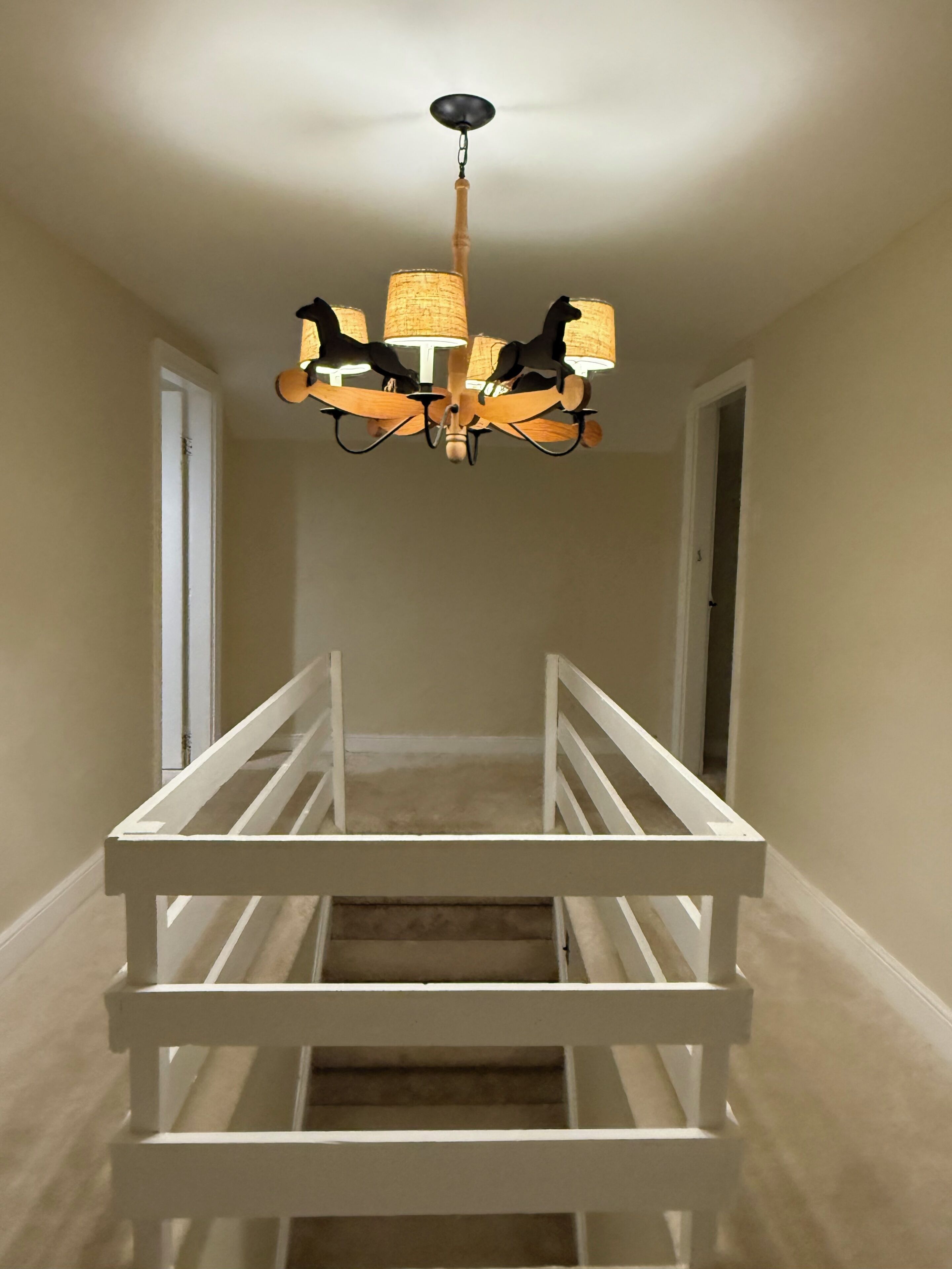 A staircase with a white railing leading up to a room.