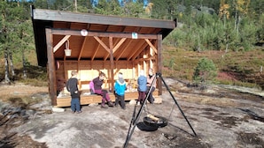 A wooden shelter with benches, surrounded by a forested area. - Great location! (Telemark)