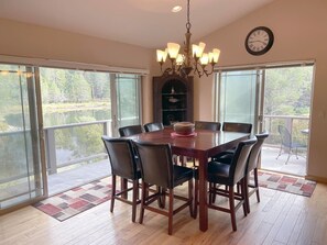 A dining room with a large table, chairs, a chandelier, and a fireplace. - Large home in the Tahoe Keys! (South Lake Tahoe)
