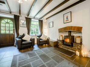A cozy room with a fireplace, two leather chairs, a rug, and a window with curtains. - 2 Bed in Llandysul (oc-85444) (Felindre)