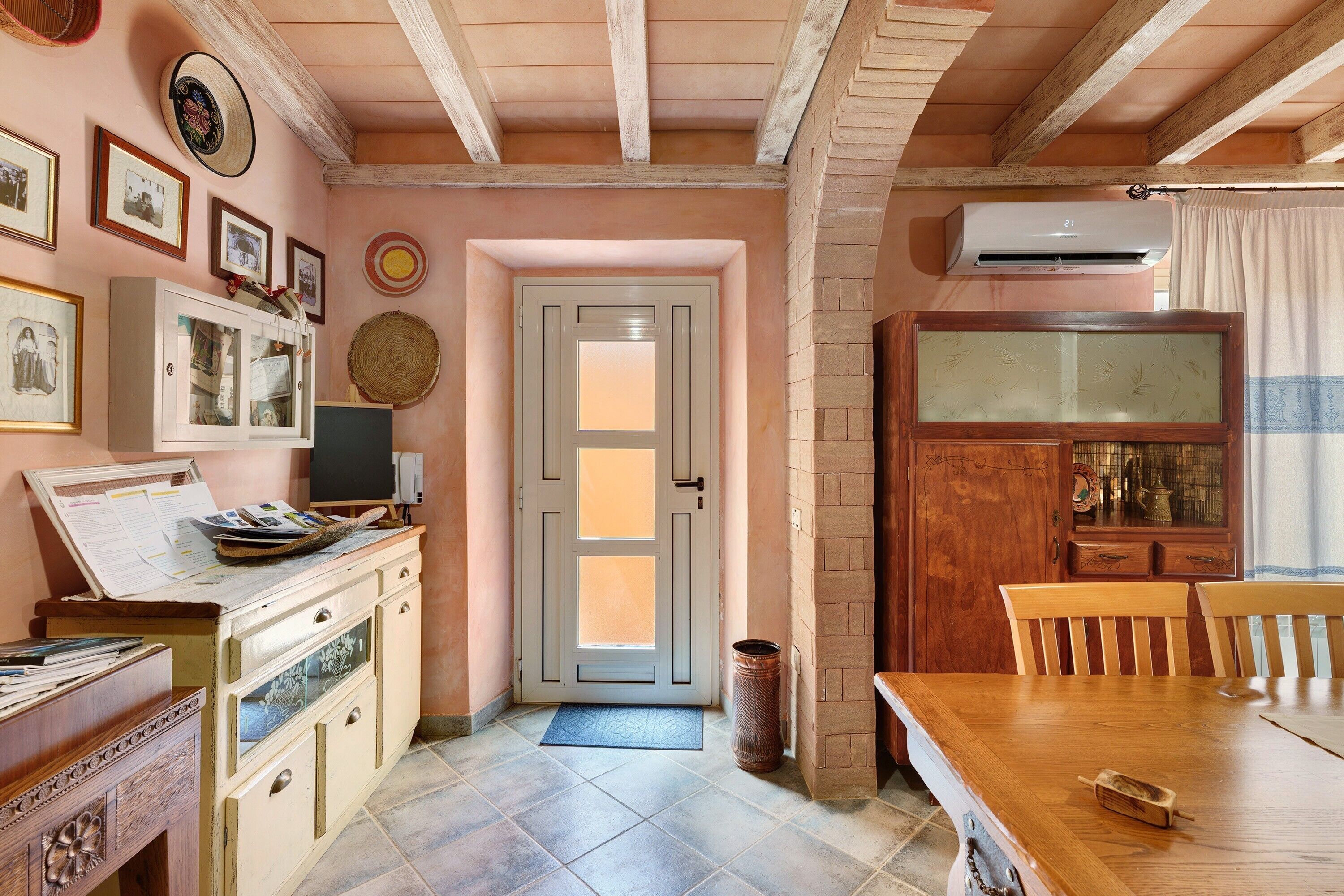 A kitchen with a wooden table, a cabinet, and a door with a window.