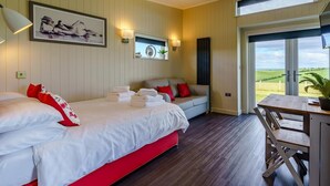 Un dormitorio con cama, sofá, mesa y vista al exterior.