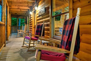 A wooden cabin with a porch, rocking chairs, and a sign that reads "Welcome to Putty Place." - Cedar Cabin Stay (Sevierville)