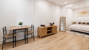 Un dormitorio moderno con cama, mesita de noche, lámpara y un espejo grande.