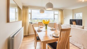 A dining area with a wooden table, chairs, and a view of the outdoors. - 2 Bed in Cockermouth (oc-sz381) (Wythop)
