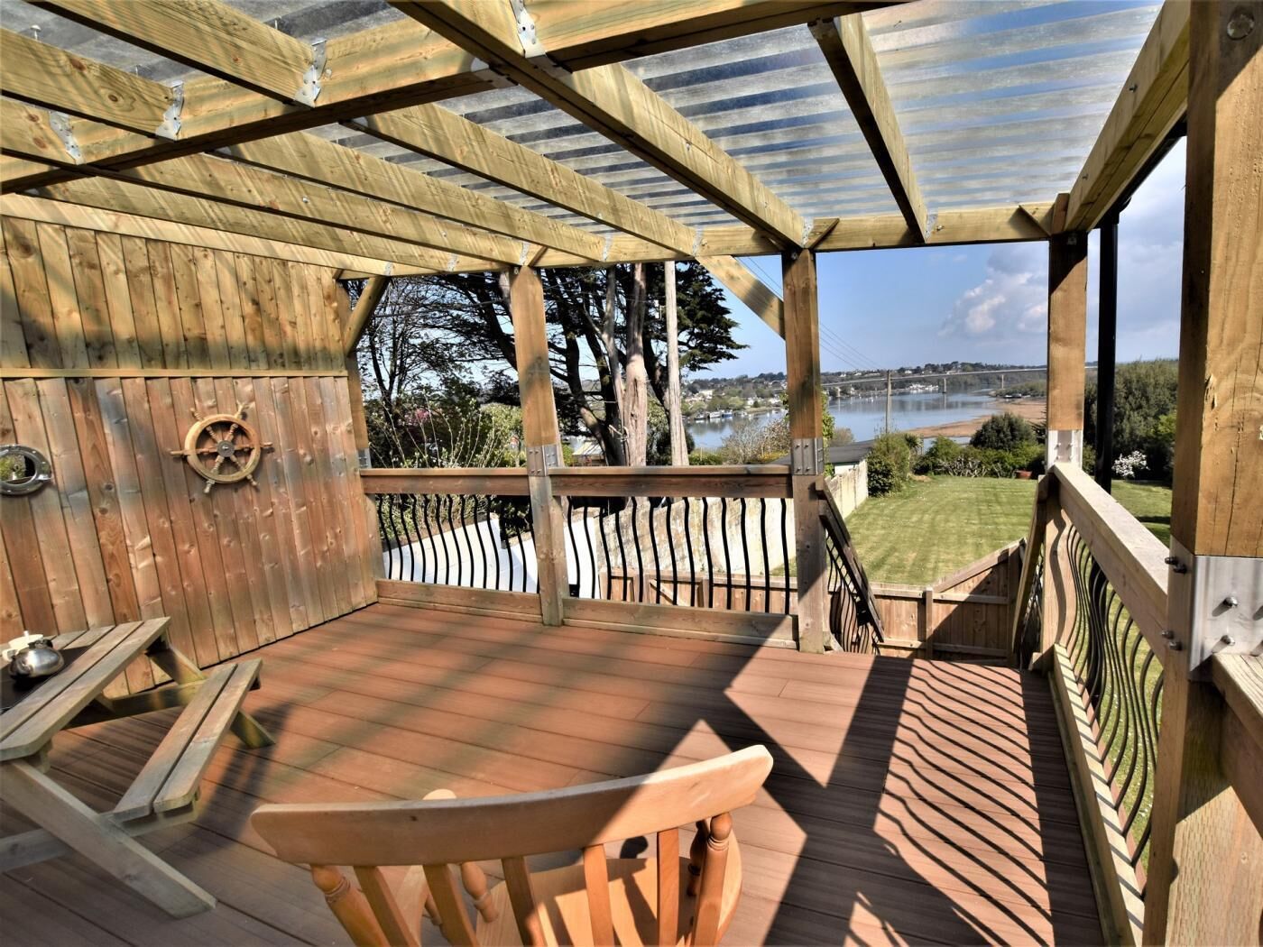 Een houten terras met uitzicht op een meer en bomen.