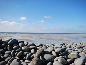 Ein Strand mit Kieselsteinen und blauem Himmel.