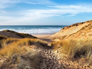 A sandy beach with dunes and a clear view of the ocean. - 3 Bed in Camber (oc-bt011) (Camber)
