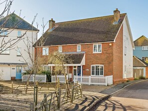 A two-story brick house with a white picket fence, a front door, and a visible garage. - 3 Bed in Camber (oc-bt011) (Camber)