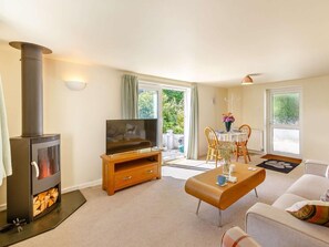 A living room with a fireplace, a television, a dining area with a table and chairs, and a sofa. - 1 Bed in Torrington (oc-46579) (Langtree)