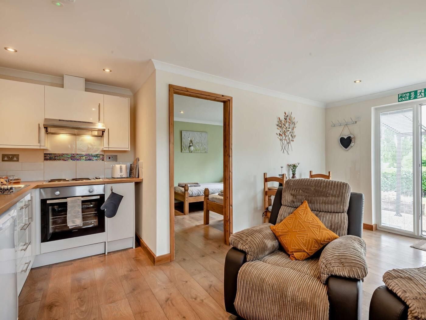 A modern kitchen with a built-in oven and a dining area with a wooden table and chairs.