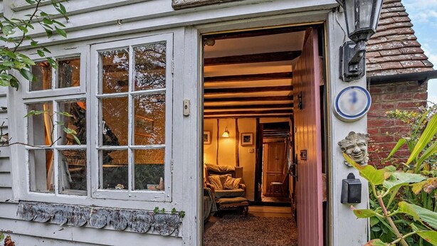 Een gezellig interieur met een houten bank, een deur met een messing handgreep en een stenen muur.