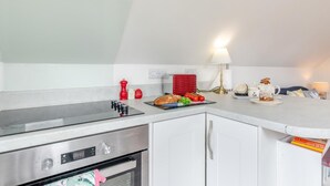 Eine moderne Küche mit Backofen, einer roten Gewürzregal und einer Arbeitsplatte mit Lebensmitteln.