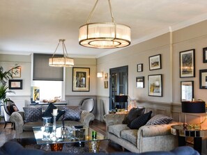 A spacious living room with two sofas, a coffee table, and a chandelier. - 5 Bed in Hurst Green (oc-46916) (Robertsbridge)