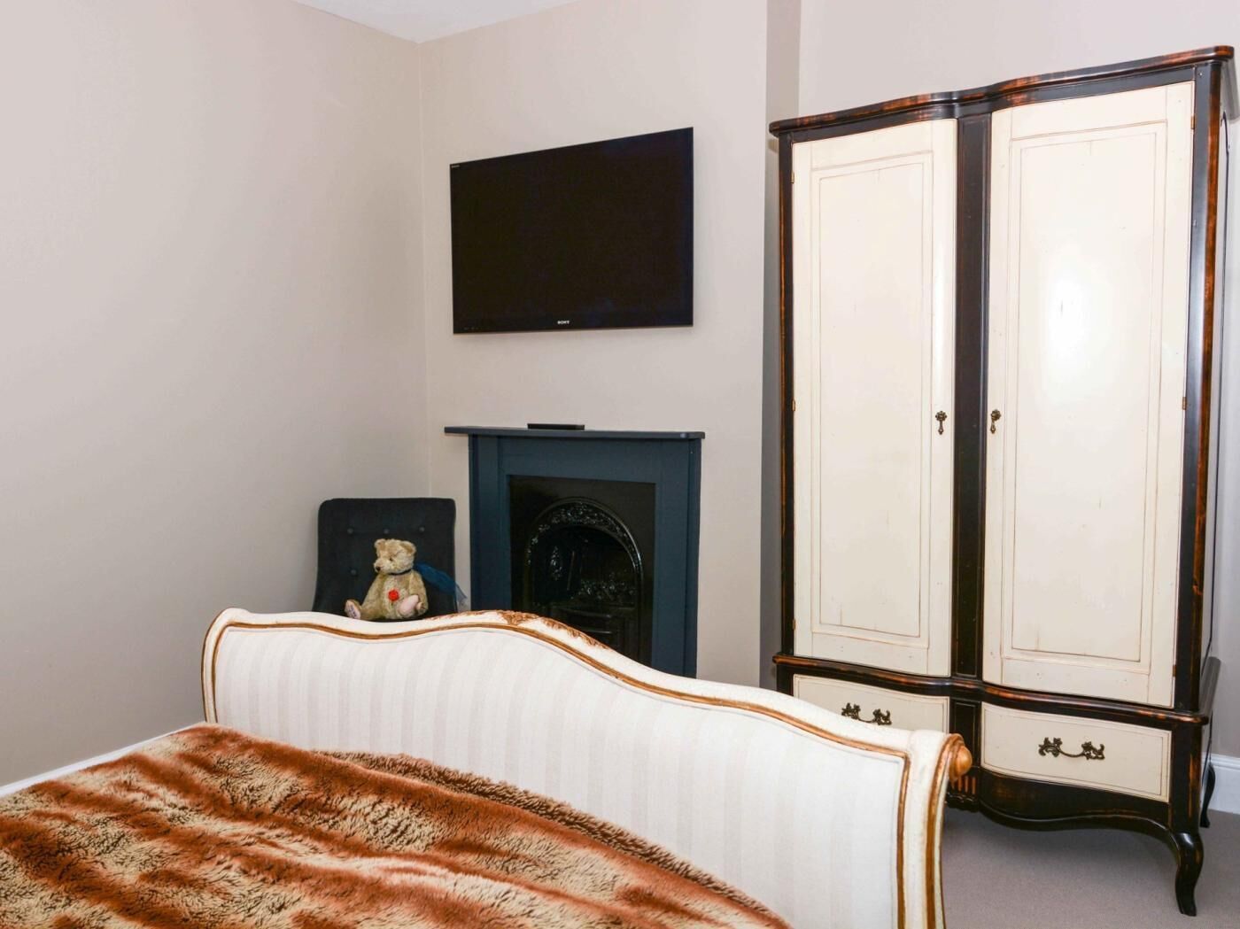 Una camera da letto con un letto, una televisione, un caminetto e un armadio.