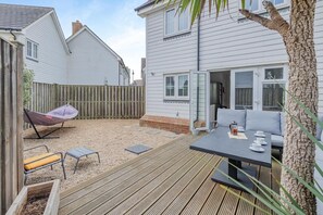 A deck with outdoor furniture, a hanging chair, and a table with cups and saucers. - 3 Bed in Camber (oc-bt044) (Camber)