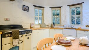 Eine Küche mit Herd, Backofen und Essbereich, gedeckt für eine Mahlzeit.