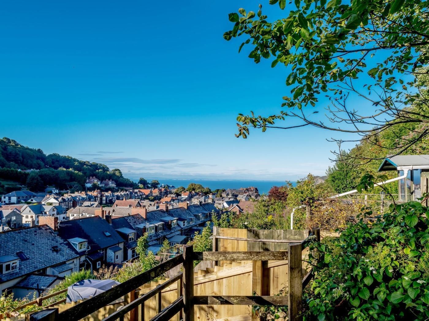 A coastal town with traditional houses, a wooden staircase, and a view of the sea.