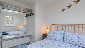 Ein Schlafzimmer mit Bett, Heizkörper, Fenster und Wandbildern.