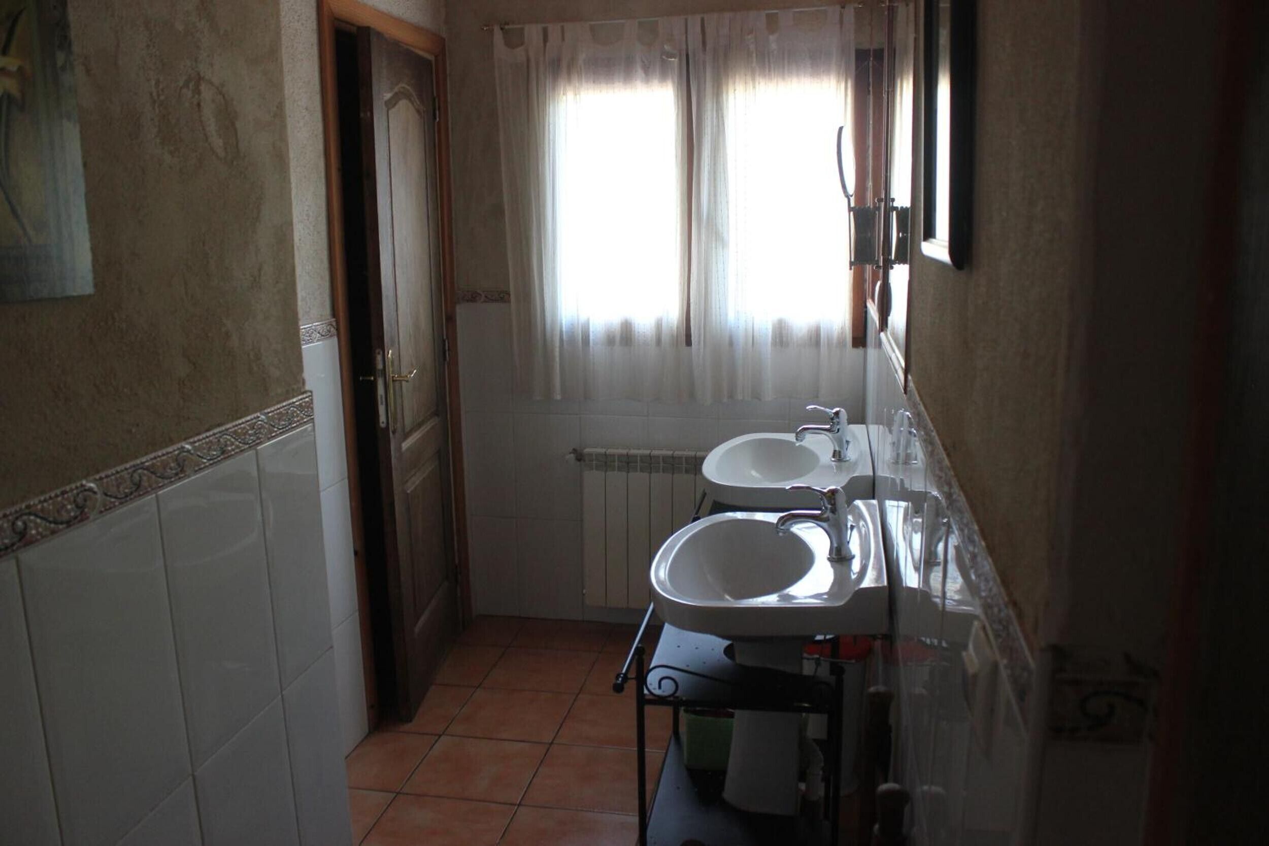 A bathroom with two sinks, a toilet, and a shower.
