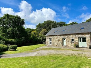 A stone building with a sloped roof, a front door, and a small window. - 2 Bed in Newport (oc-78803) (Llwyngwair Manor)