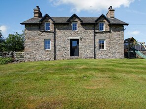A stone building with a central entrance, multiple windows, and a grassy yard. - 3 Bed in Pitlochry (oc-78841) (Dalchalloch)