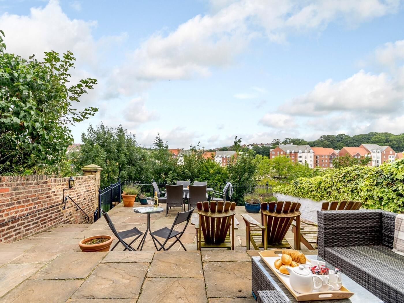 Une terrasse extérieure avec des sièges, une table et un plateau de nourriture.