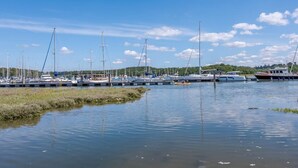 Een jachthaven met verschillende boten afgemeerd, kalm water en een heldere lucht.