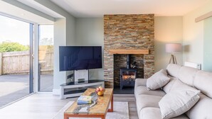 Ein modernes Wohnzimmer mit Kamin, Flachbildfernseher und einer Couch.