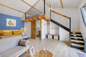 Un interior moderno con una zona de descanso tipo loft, una escalera y una sala de estar con un sofá y una mesa de centro.