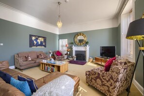 A living room with a sofa set, a coffee table, a fireplace, and a television. - 5 Bed in Melrose (oc-79418) (Melrose)