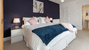 A bedroom with a bed, nightstands, a lamp, a painting, and a door. - 5 Bed in Melrose (oc-79418) (Melrose)
