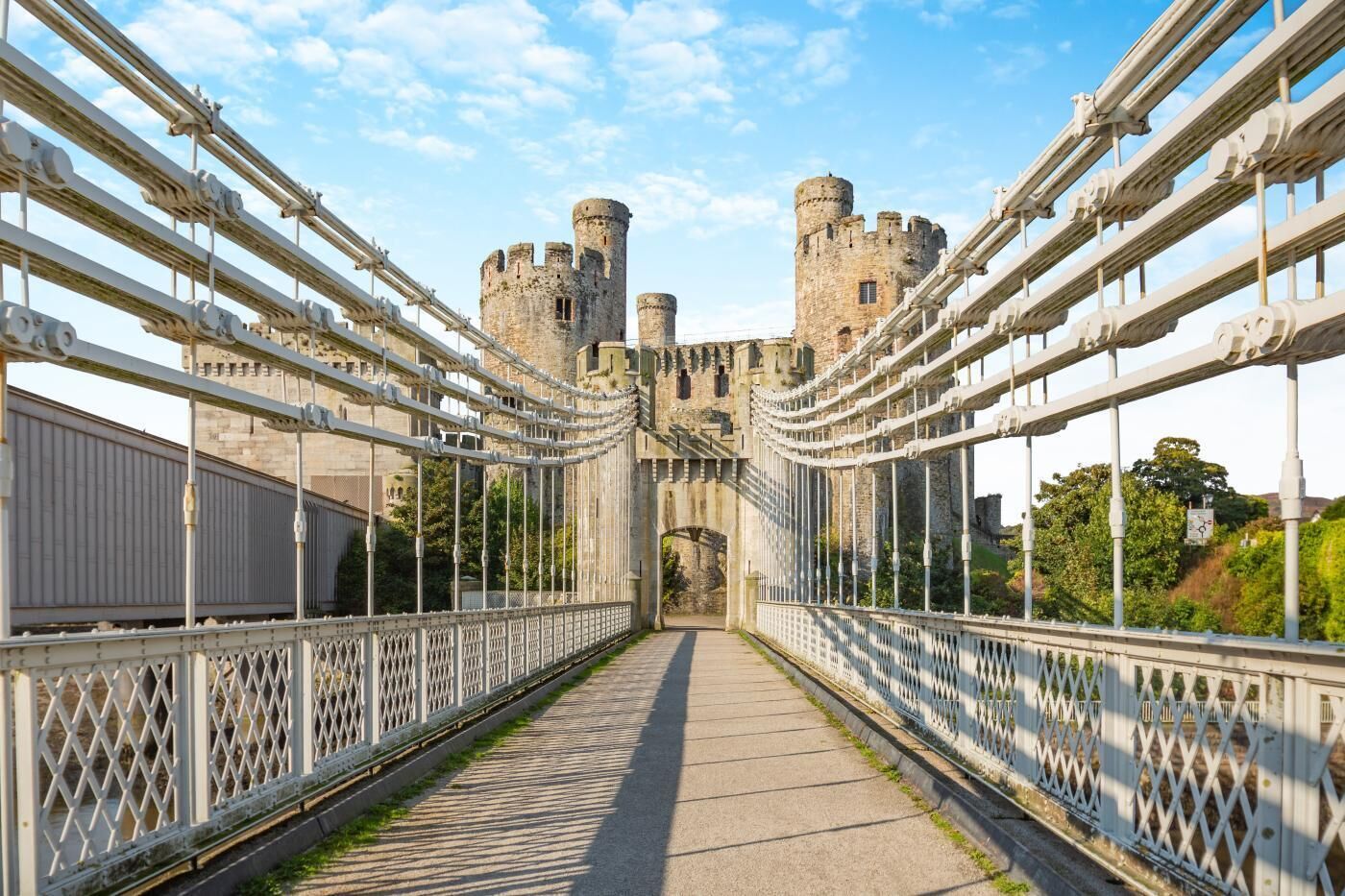 Eine Fußgängerbrücke mit einer Burg im Hintergrund.
