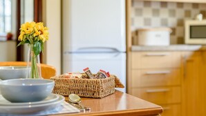 Eine Küche mit Kühlschrank, Mikrowelle und Holzschränken.