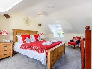 A bedroom with a wooden bed, a nightstand, a chair, a window, and a ceiling light. - 1 Bed in Conwy (oc-79357) (Ty'n-y-groes)