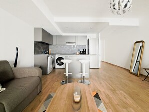 A modern apartment with a living room, kitchen, and a dining area. - Studio Near Cannes City Center with Air Conditioning and Parking - Benakey (Cannes)