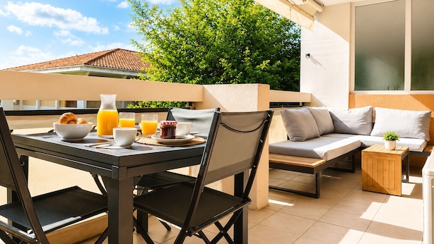 An outdoor dining area with a table, chairs, and a sofa. - Sunny Terrace & Open Views | Pool, Parking, A/C | Cannes – BENAKEY (Cannes)