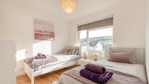 A bedroom with two beds, a window with a view, and a painting on the wall. - 2 Bed in Wareham (oc-79228) (West Lulworth)