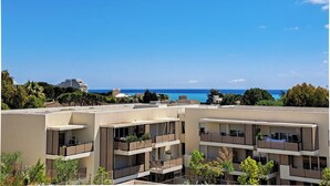 A modern multi-story building with balconies, a clear blue sky, and a view of the sea. - 2B Near Vaugrenier, AC, terrace, sea view, swimming pool, parking- BENAKEY (Villeneuve-Loubet)