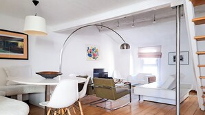 Un soggiorno moderno con un divano bianco, un tavolo da pranzo e una TV.