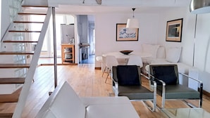 Un interno moderno con una scala, una zona pranzo e un soggiorno.