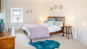 A bedroom with a bed, bedside tables, a window, a dresser, and a blue rug. - 3 Bed in Narberth (oc-79443) (Narberth)