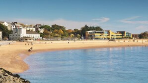 Ein Strand mit Gebäuden im Hintergrund.