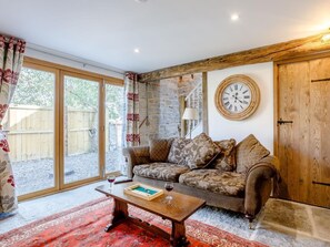 A cozy living room with a wooden sofa, a coffee table, and a large window. - 2 Bed in Glastonbury (oc-79122) (Glastonbury)