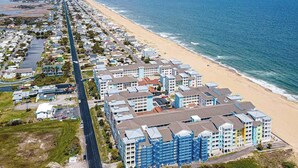 Una zona residencial costera con una larga avenida, propiedades frente al mar y una playa.