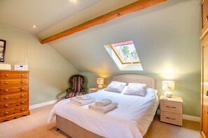 A bedroom with a sloped ceiling, a bed with pillows, a chair, a dresser, bedside lamps, and a window. - 2 Bed in Huby (oc-79166) (Weeton)