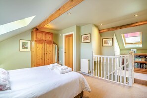 A bedroom with a bed, wooden wardrobe, and a staircase leading to a loft area with bookshelves. - 2 Bed in Huby (oc-79166) (Weeton)
